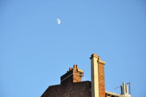 Luna pe cerul albastru în timpul zilei, alături de un coș de fum, fotografie din 2009